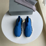 Scarpe futuristiche blu su tavolo elegante con scatola e calzini grigi, stile moderno e di lusso.