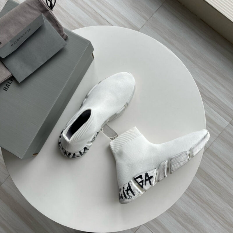 Sneaker moderne con dettagli grafici su tavolino bianco in stile minimal e fashion contemporaneo.