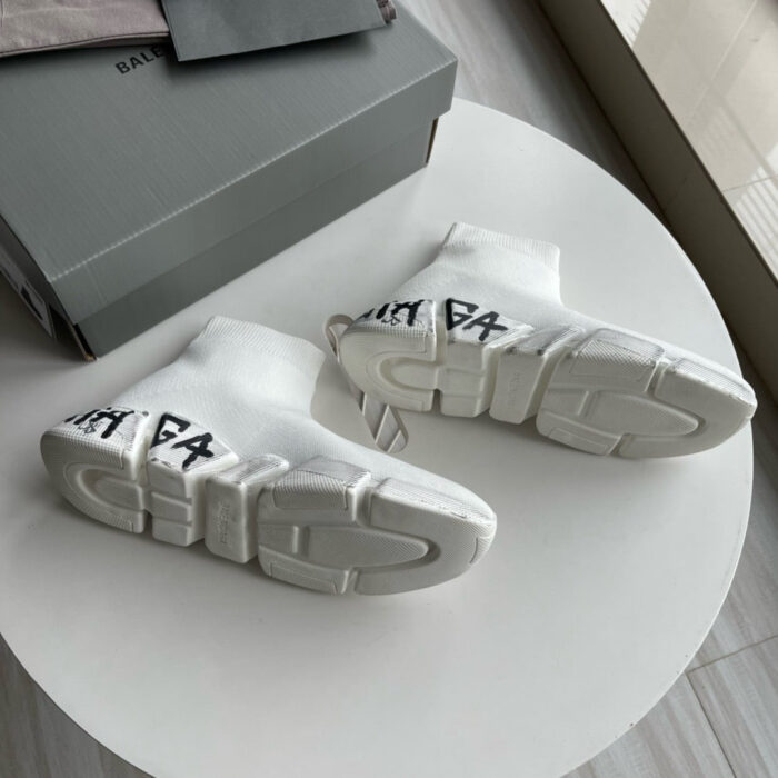 Sneakers Balenciaga bianche con logo nero, in scatola minimalista su sfondo luminoso.