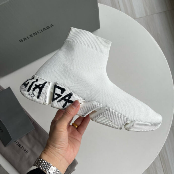 Sneaker Balenciaga bianca con suola trasparente e logo prominente, stile moderno e minimalista.
