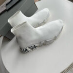 Sneaker moderne bianche con suola chunky e logo visibile sul tallone.