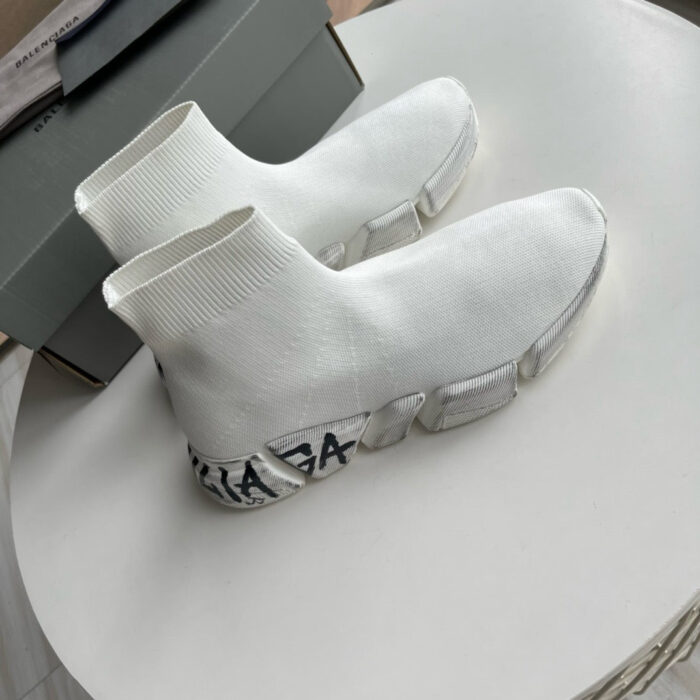 Sneaker moderne bianche con suola chunky e logo visibile sul tallone.