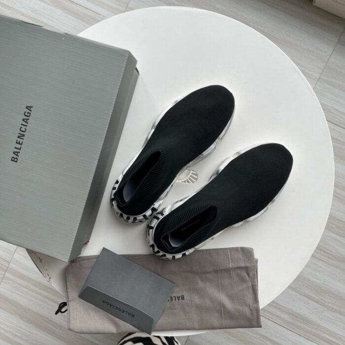 Scarpe Balenciaga di lusso con scatola e accessori su tavolo elegante.