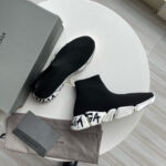 Sneakers Balenciaga high-top neri, stile sportivo e di lusso, su tavolo chiaro con scatola.