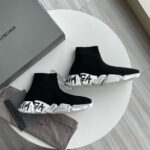 Sneakers Balenciaga nere in tessuto con suola bianca e dettagli branding distintivi.