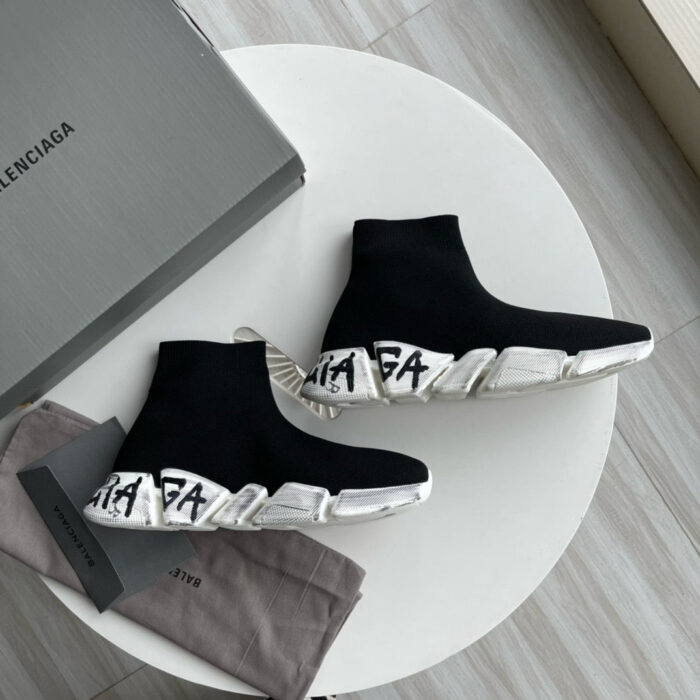 Sneakers Balenciaga nere in tessuto con suola bianca e dettagli branding distintivi.