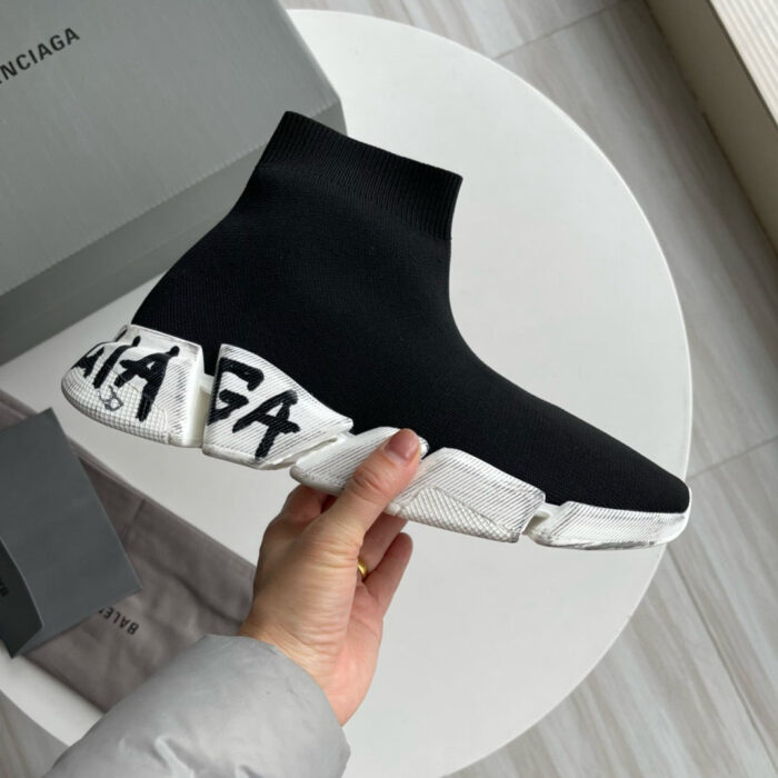 Sneaker Balenciaga high-top nero con suola bianca e logo audace, stile trendy e minimalista.