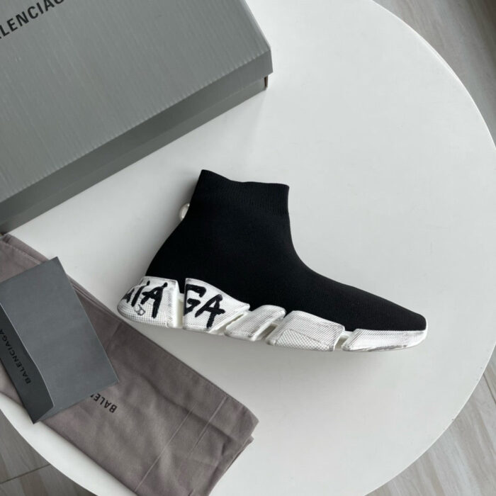 Sneaker Balenciaga nera con suola bianca e logo, su tavolo moderno e elegante.