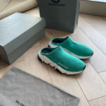 Sneakers Balenciaga turquoise con scatola minimalista e dust bag su pavimento in legno chiaro