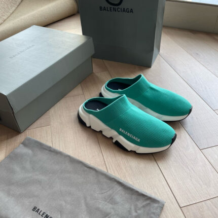 Sneakers Balenciaga turquoise con scatola minimalista e dust bag su pavimento in legno chiaro