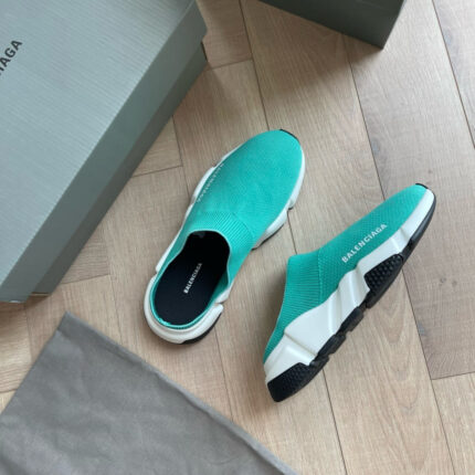 Scarpe Balenciaga moderne in turquoise con suola nera e design minimalista su pavimento in legno.