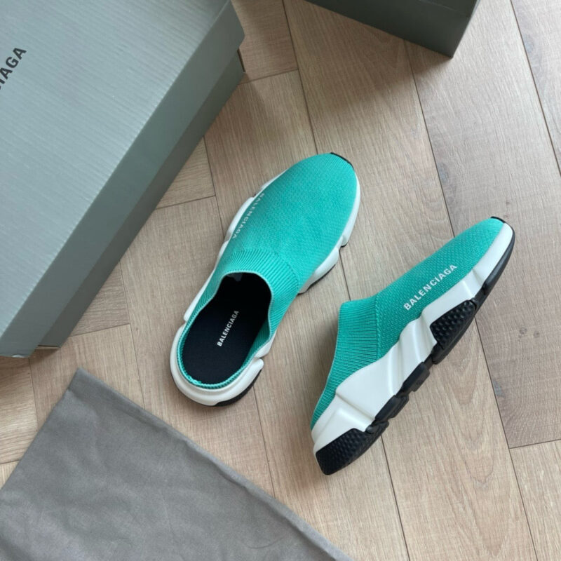 Scarpe Balenciaga moderne in turquoise con suola nera e design minimalista su pavimento in legno.