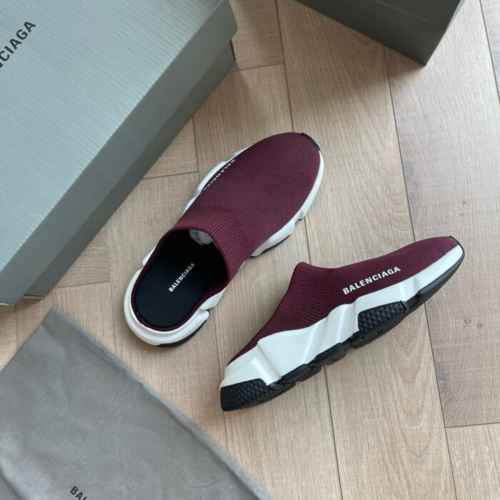 Sneakers slip-on Balenciaga bordeaux minimaliste su sottofondo in legno.