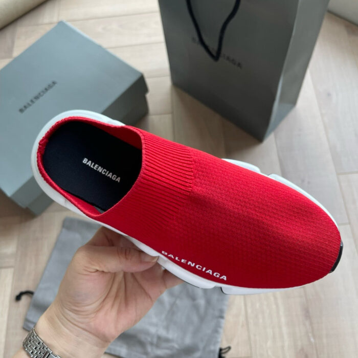 Sneaker rossa Balenciaga di lusso, stile moderno e design elegante, su sfondo in pelliccia e negozio.
