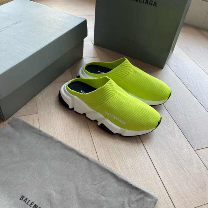 Scarpe slip-on verdi lime Balenciaga con scatole di lusso e borsa elegante in ambientazione moderna.
