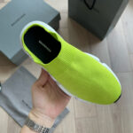 Sneaker neon giallo Balenciaga, stile moderno, packaging di lusso e design minimalista.