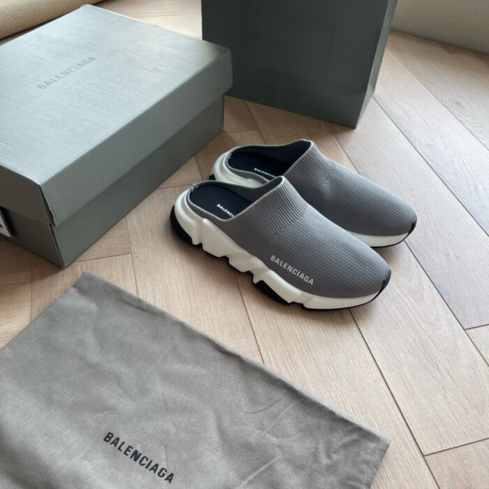 Scarpe Balenciaga slip-on grigie con suola spessa, eleganti e moderne su pavimento di legno.
