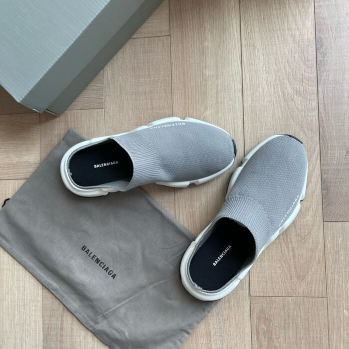Scarpe da corsa grigie con scatola e borsa protettiva, stile moderno e design minimalista.