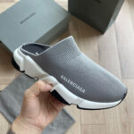 Scarpe slip-on Balenciaga grigie con suola bianca trendy e logo visibile.
