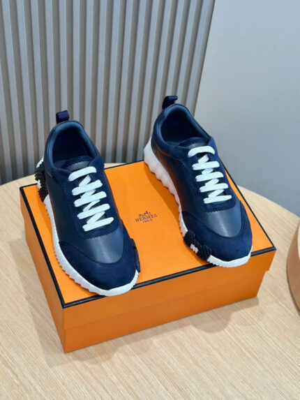 Sneakers navy blu con lacci bianchi, su scatola arancione, stile moderno e di tendenza.