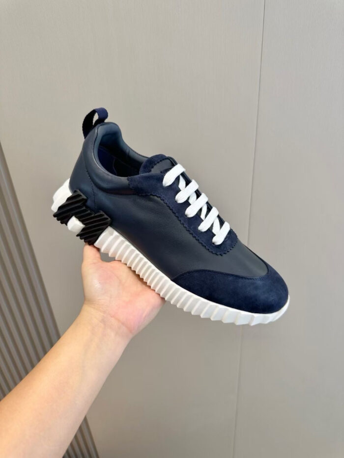 Scarpa sneaker moderna navy con suola bianca robusta e dettagli eleganti.