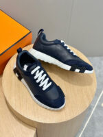 Scarpe da ginnastica navy con suola bianca e design moderno su pedestal in legno.
