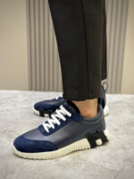 Sneaker navy blu con pantaloni eleganti, stile street fashion e design moderno.