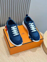 Sneakers navy blu con dettagli rossi su scatola orange, stile moderno e versatile, originalità e eleganza.