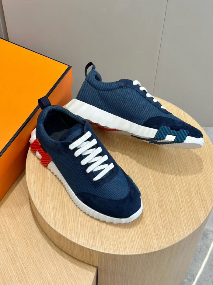 Sneakers navy e bianco con dettagli rossi, stile sportivo e design moderno su tavolo in legno.