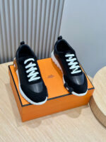 Sneakers nere di design con scatola arancione, stile moderno e look elegante per ogni occasione.