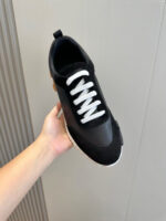 Sneaker nera moderna con lacci bianchi, suola spessa e design elegante per stile e comfort.