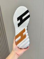 Sottopiede di sneaker con dettagli in bianco, nero e arancione per grip e estetica moderna.