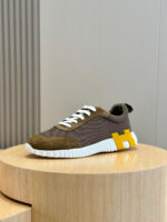 Sneaker moderna con logo giallo su pedestallo di legno, stile elegante e comfort quotidiano.