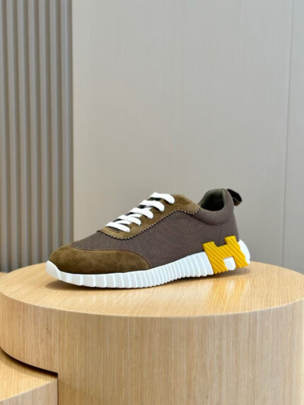 Sneaker moderna con logo giallo su pedestallo di legno, stile elegante e comfort quotidiano.