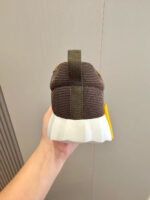 Sneaker moderna marrone con suola bianca e dettaglio giallo, stile urbano e comfort.