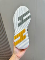 Suola sportiva moderna con onde, dettaglio grigio e giallo, ottima aderenza e stile urban.