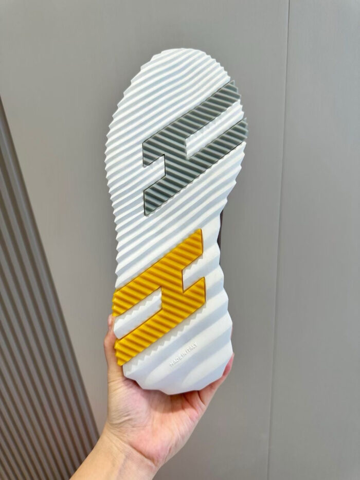 Suola sportiva moderna con onde, dettaglio grigio e giallo, ottima aderenza e stile urban.