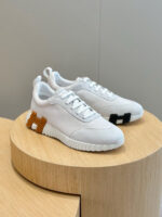 Sneaker moderne bianca con dettagli colorati e design minimalista su pedana in legno.