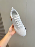Scarpa sneakers bianca moderna minimalista con suola stabile e dettagli eleganti.