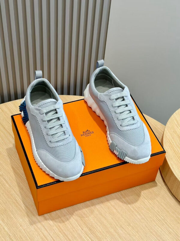 Scarpe sportive grigie moderne su scatola arancione di lusso, stile minimalista e design elegante.