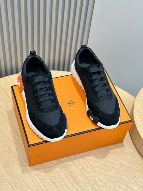 Sneakers nere moderne su scatola arancione, stile casual e sportivo, design elegante e comfort elevato.