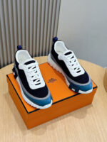 Sneaker moderne blu navy su scatola arancione, stile casual e comfort eleganti.