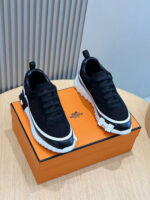 Sneakers nere oversize su box arancione, stile streetwear e comfort moderno.