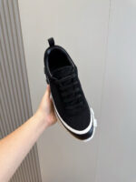 Sneaker nera moderna con suola bianca, design elegante e comfort per casual e sportivo.