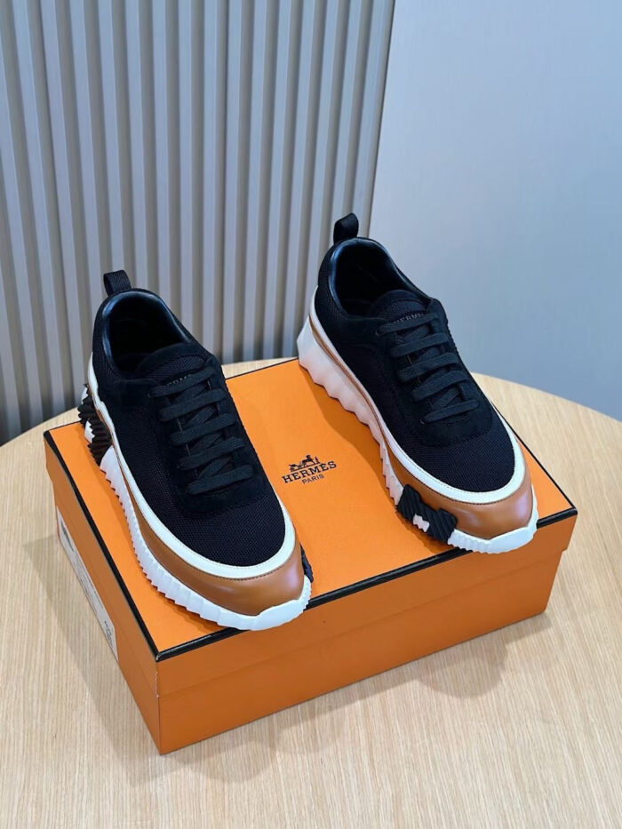 Sneakers moderne con dettagli bronzo su scatola arancione, stile urbano e design sportivo.
