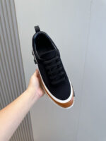 Sneaker nera moderna con dettagli bianchi e marrone, stile casual e versatile.