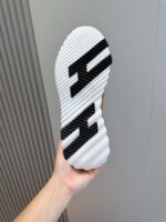 Sole sneakers sportivi con logo stilizzato, trazione e design moderno, ideale per attività sportive e casual.