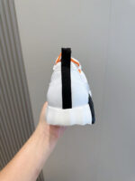 Sneaker moderna bianca, nera e arancione, stile minimalista e design elegante.