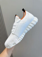 Sneaker bianca moderna con suola spessa, dettagli colorati e design minimalista trendy