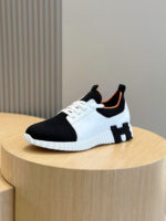 Sneaker moderna bianca e nera su pedestallo in legno, design elegante e comfort sportivo.